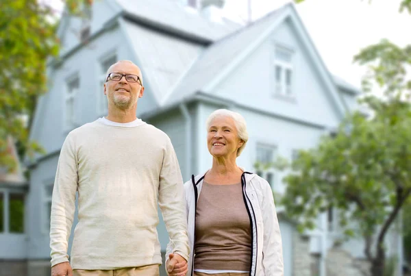 Glückliches Seniorenpaar hält Hand über Haus — Stockfoto