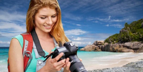 Kobieta z plecaka i kamery na plaży — Zdjęcie stockowe