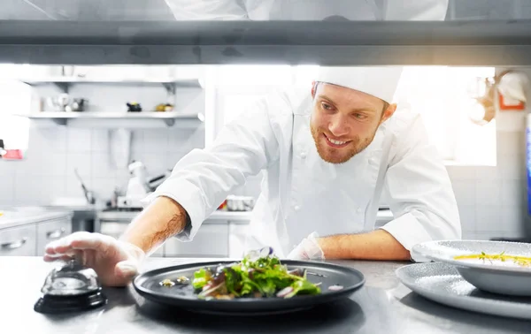 Chef masculino feliz cozinhar comida na cozinha do restaurante — Fotografia de Stock
