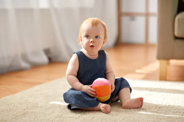 Linda menina ruiva com bola de brinquedo em casa — Fotografia de Stock