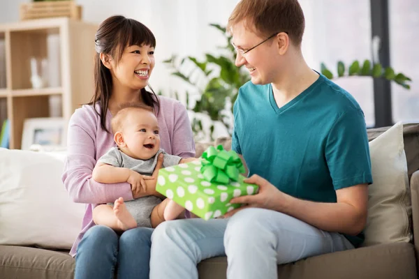 Mutter mit Baby übergibt Geburtstagsgeschenk an Vater — Stockfoto