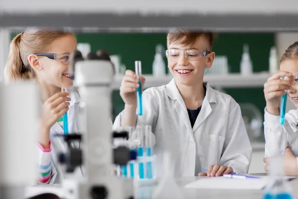 Niños con tubos de ensayo que estudian química en la escuela — Foto de Stock