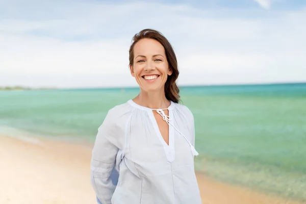 Счастливая улыбающаяся женщина на летнем пляже — стоковое фото