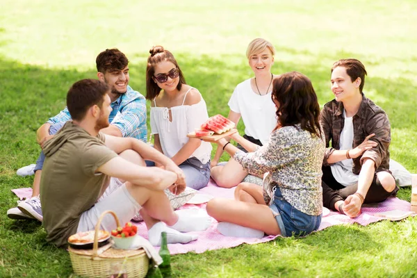 Amici felici mangiare anguria al picnic estivo — Foto Stock