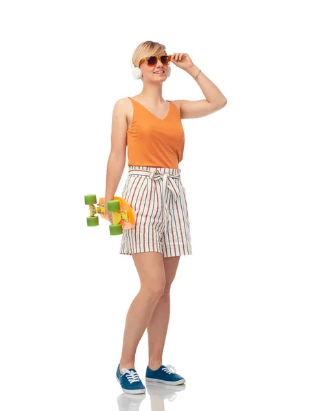 Smiling teenage girl with skateboard over white — Stock Photo, Image