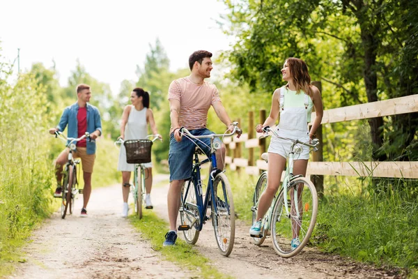 Glada vänner med fasta redskap cyklar i sommar — Stockfoto