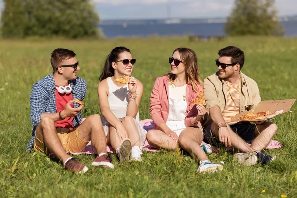 Przyjaciele jedzenie pizzy piknik w parku lato — Zdjęcie stockowe