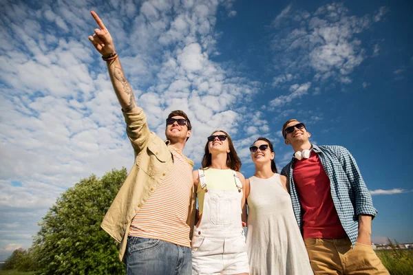 Amici felici guardando qualcosa all'aperto — Foto Stock