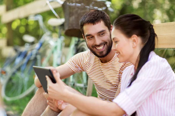 Couple with tablet pc and bicycles at summer park — Stock Photo, Image