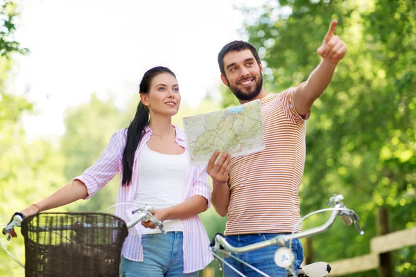 Echtpaar met kaart en fietsen op land in de zomer — Stockfoto