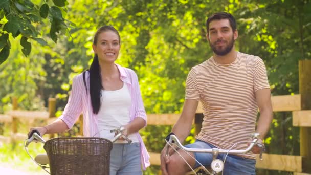 Ευτυχισμένο ζευγάρι με τα ποδήλατα μιλούν στο πάρκο καλοκαίρι — Αρχείο Βίντεο