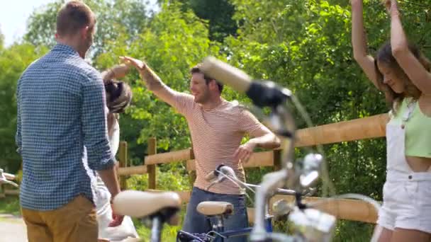 Amigos felizes com bicicletas dançando no parque de verão — Vídeo de Stock