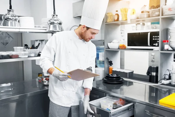 Chef com área de transferência fazendo inventário na cozinha — Fotografia de Stock