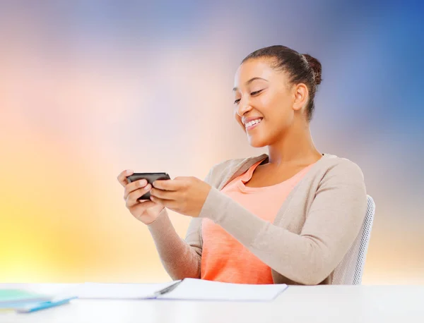 Chica estudiante africana con smartphone y cuadernos — Foto de Stock