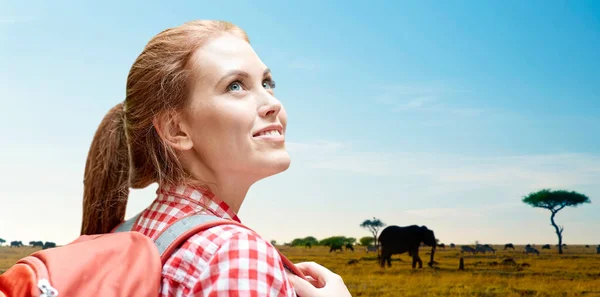 Mulher feliz com mochila sobre savana africana — Fotografia de Stock