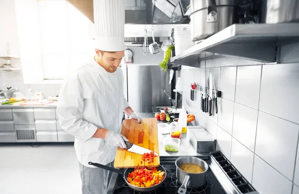 Male chef cooking food at restaurant kitchen — Stock Photo, Image