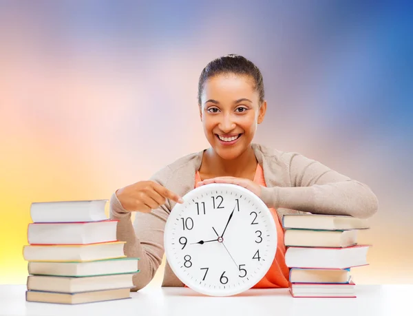 Étudiant fille avec livres montrant le temps sur horloge — Photo