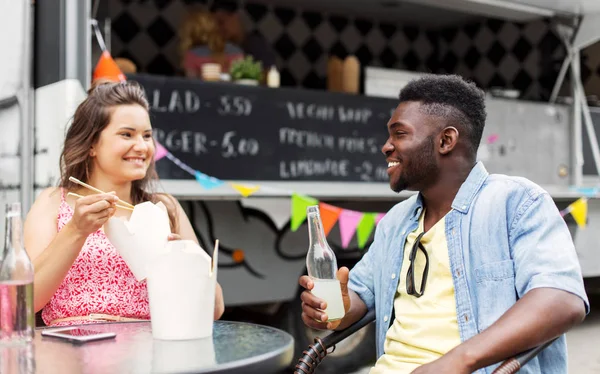 Mixed race couple eating and talking at food truck — Stock Photo, Image