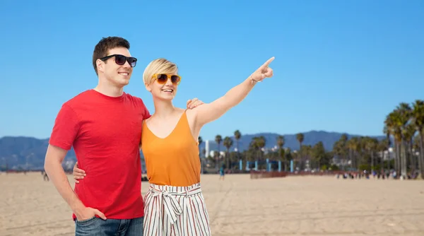 Улыбающаяся пара в солнечных очках, обнимающая — стоковое фото