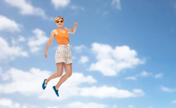 하늘 위로 점프 하는 선글라스에 행복 한 십 대 소녀 — 스톡 사진