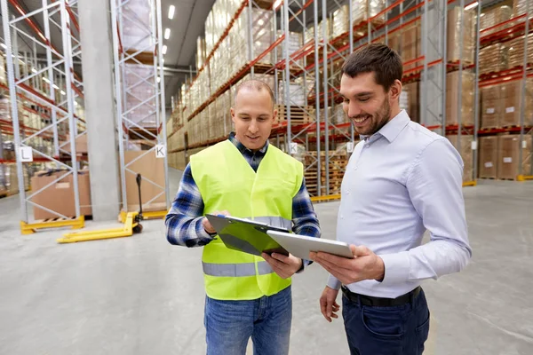 Trabalhador e empresário com tablet pc no armazém — Fotografia de Stock