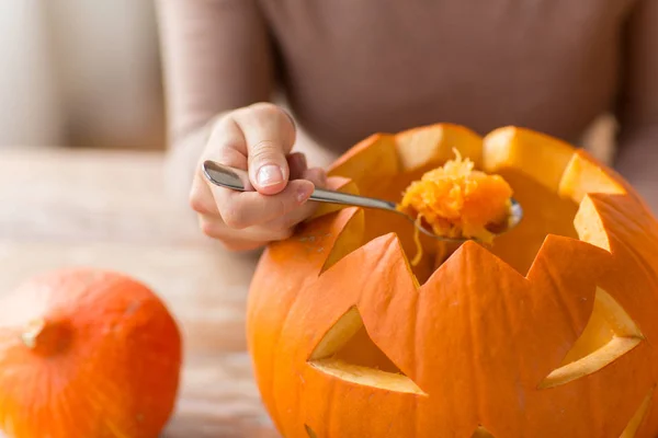 Nahaufnahme einer Frau, die Halloween-Kürbis schnitzt — Stockfoto