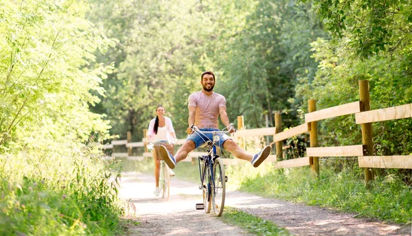 Feliz pareja con bicicletas en el parque de verano —  Fotos de Stock