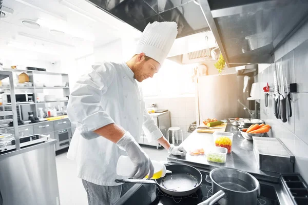 Chef masculino feliz cozinhar comida na cozinha do restaurante — Fotografia de Stock