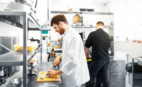 Kuchař a kuchařka vaření v kuchyni restaurace — Stock fotografie