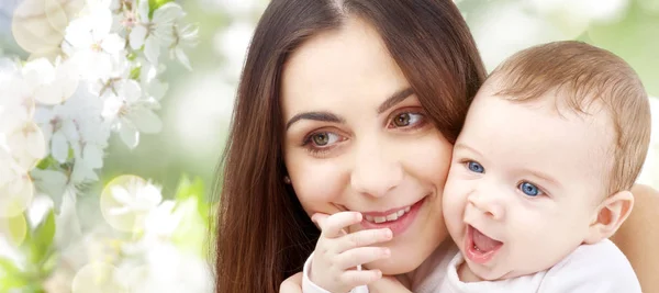 Kiraz çiçeği arka plan üzerinde bebek ile anne — Stok fotoğraf