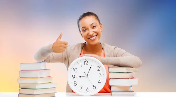 Estudante com livros e relógio mostrando polegares para cima — Fotografia de Stock