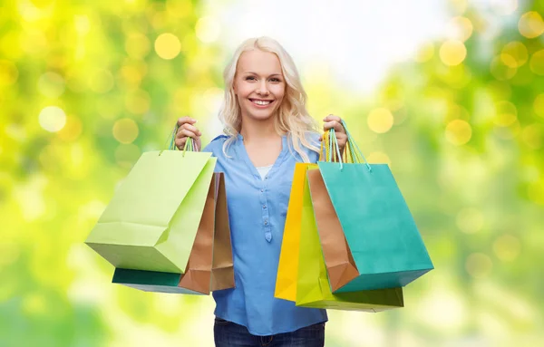 Mujer joven con bolsas de compras sobre luces —  Fotos de Stock