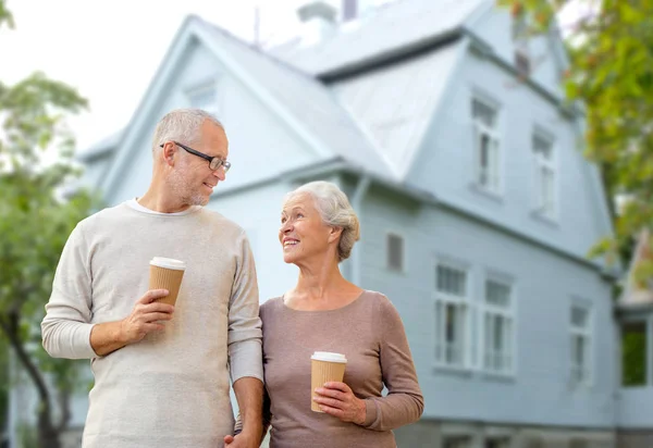 Щаслива старша пара з кавою над житловим будинком — стокове фото