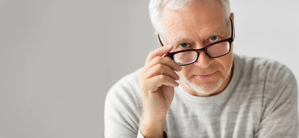 Крупным планом пожилого человека в очках, думающего — стоковое фото