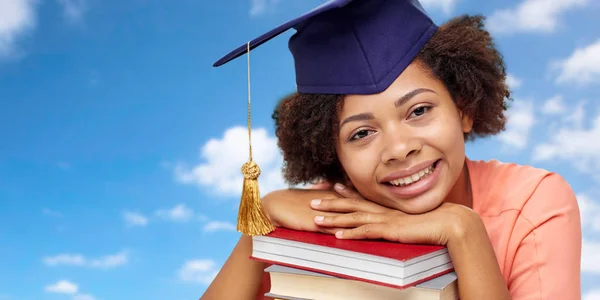 Close up of african graduate student with books — Stock Photo, Image