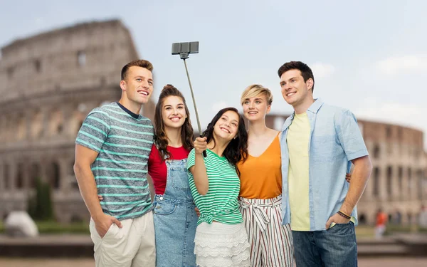 Friends taking selfie by monopod over coliseum — Stock Photo, Image