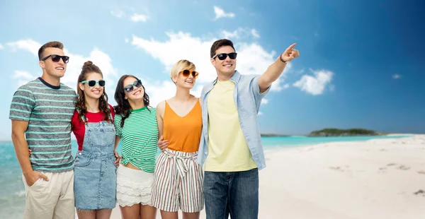 Друзья в солнечных очках над тропическим пляжем — стоковое фото