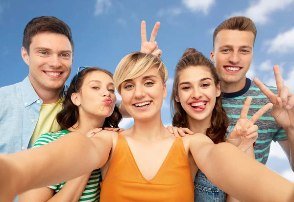 Happy friends taking selfie and showing peace — Stock Photo, Image