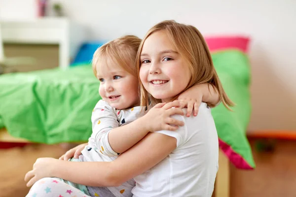 Meninas ou irmãs felizes abraçando em casa — Fotografia de Stock