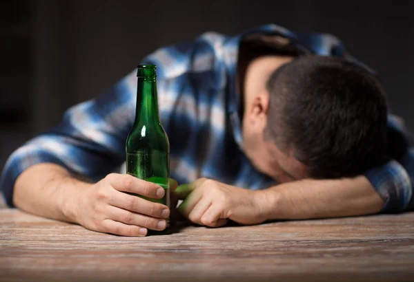 Uomo ubriaco con bottiglie di birra sul tavolo di notte — Foto Stock