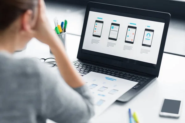 Stressed designer with user interface on laptop — Stock Photo, Image