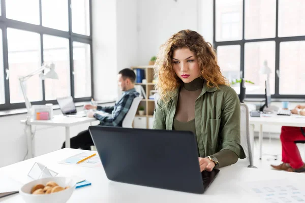 Креативная женщина с ноутбуком работает в офисе — стоковое фото