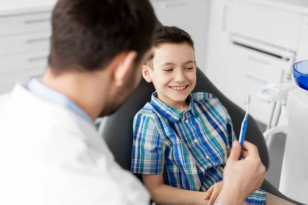 Dentysta, dając szczoteczka do dziecko pacjenta w klinice — Zdjęcie stockowe