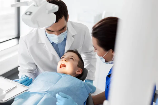 Dentista alla ricerca di denti per bambini presso la clinica dentistica — Foto Stock