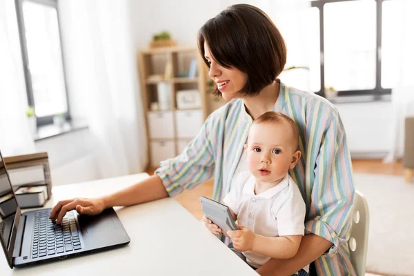 Werkende moeder met baby jongen en laptop thuis — Stockfoto