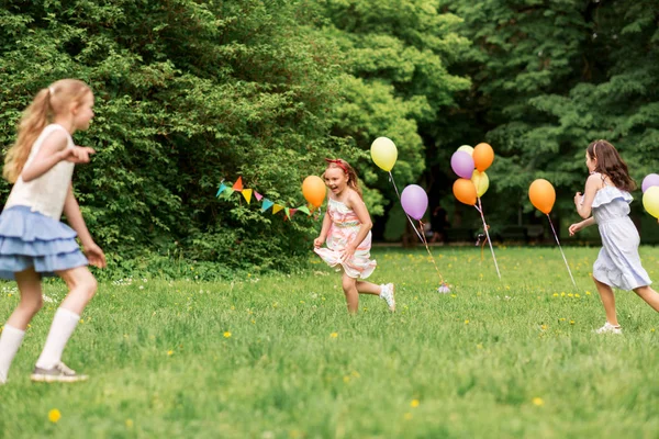 Niñas felices jugando juego de etiquetas en la fiesta de cumpleaños —  Fotos de Stock