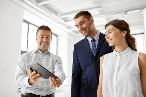 Makelaar tablet pc tonen aan klanten op kantoor — Stockfoto