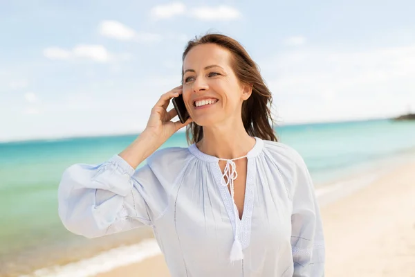 Šťastná žena volá na smartphone na letní beach — Stock fotografie