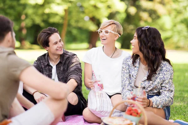 Gelukkige vrienden met dranken op zomerpicknick — Stockfoto