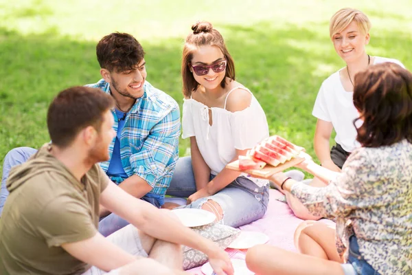 Ευτυχείς φίλοι τρώγοντας καρπούζι στο πικ νικ το καλοκαίρι — Φωτογραφία Αρχείου